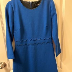 Frilly monochromatic blue dress with scalloping at waist in front and back.